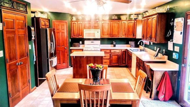 7751 E Fibia Pl, Fort Wayne, IN 46818 - kitchen with white appliances, a sink, light countertops, a center island, and a ceiling fan