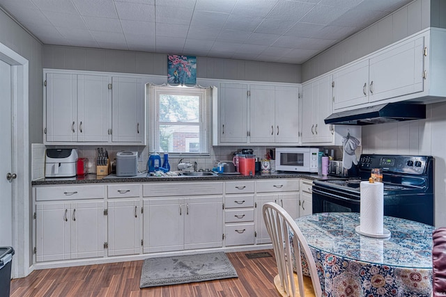 1616 N Roosevelt Dr, Evansville, IN 47711 - kitchen with white microwave, black electric range, under cabinet range hood, and white cabinets