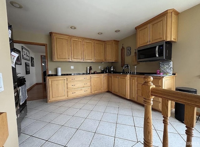 312 W Columbia St, Oakland City, IN 47660 - kitchen with stainless steel microwave, light tile patterned floors, a sink, recessed lighting, and light brown cabinets