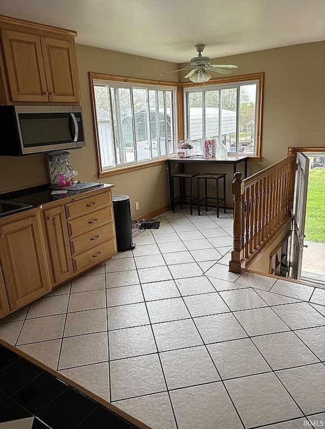312 W Columbia St, Oakland City, IN 47660 - kitchen with stainless steel microwave, plenty of natural light, and light tile patterned flooring