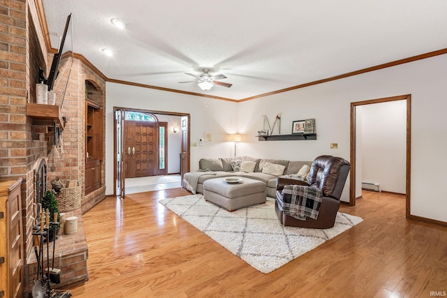 13392 N State Road 13, North Manchester, IN 46962 - living room with baseboard heating, light wood-style flooring, ceiling fan, a brick fireplace, and baseboards