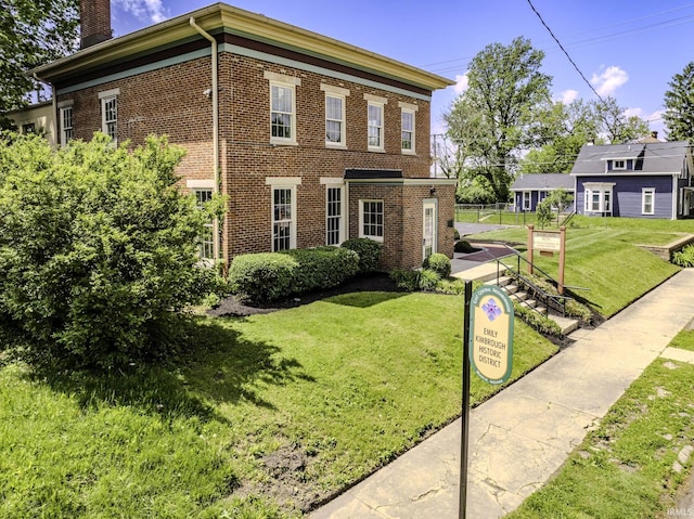 607 E Charles St, Muncie, IN 47305 - view of home's exterior featuring brick siding, a chimney, and a lawn