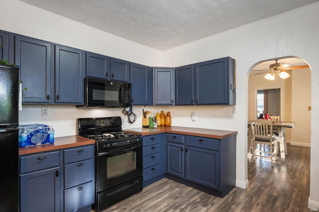 kitchen featuring black appliances, blue cabinets, arched walkways, dark wood-style flooring, and a textured ceiling