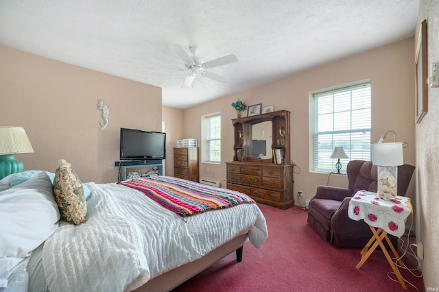 carpeted bedroom with baseboard heating and a ceiling fan