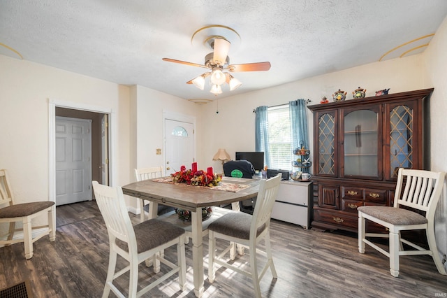 dining space with dark wood-style floors, a textured ceiling, and a ceiling fan