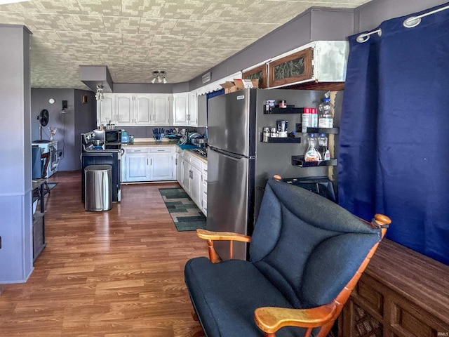 315 W Butcher St, Geneva, IN 46740 - kitchen featuring white cabinetry, an ornate ceiling, dark wood-style flooring, and freestanding refrigerator
