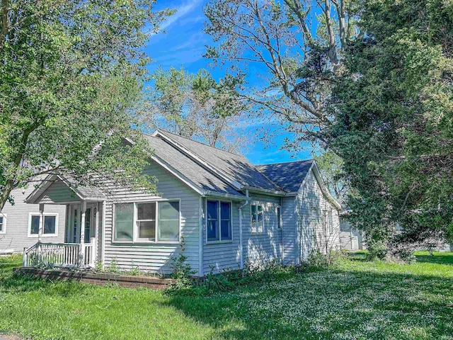 315 W Butcher St, Geneva, IN 46740 - view of side of home with a lawn and a shingled roof