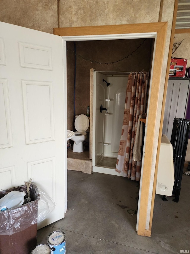 bathroom with a shower stall, unfinished concrete flooring, and toilet