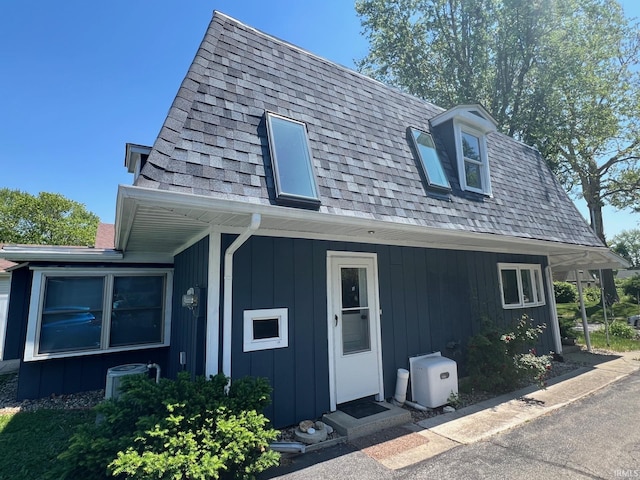1206 King St, Lafayette, IN 47905 - view of front of property featuring a shingled roof, central air condition unit, mansard roof, and board and batten siding