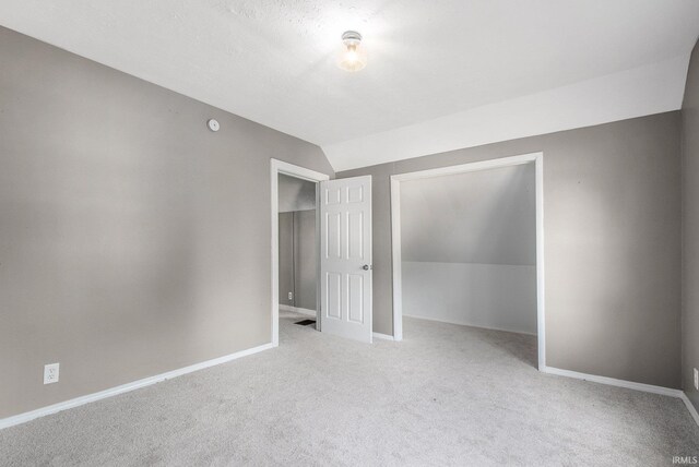 1614 Kendall St, South Bend, IN 46613 - unfurnished bedroom featuring carpet floors, a closet, vaulted ceiling, and baseboards
