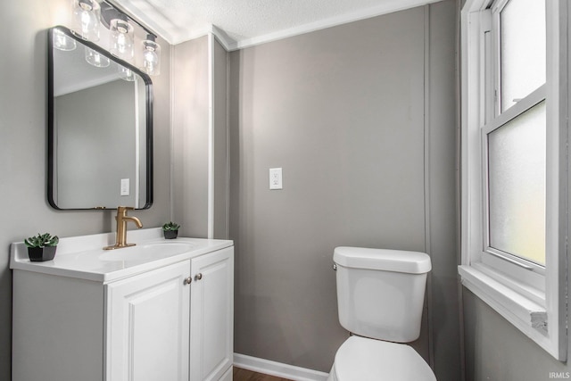 1614 Kendall St, South Bend, IN 46613 - bathroom featuring toilet, vanity, a textured ceiling, baseboards, and wood finished floors