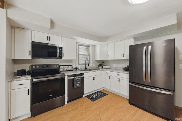 7956 N 225 W, Delphi, IN 46923 - kitchen featuring stainless steel appliances, a sink, white cabinets, and light wood-type flooring