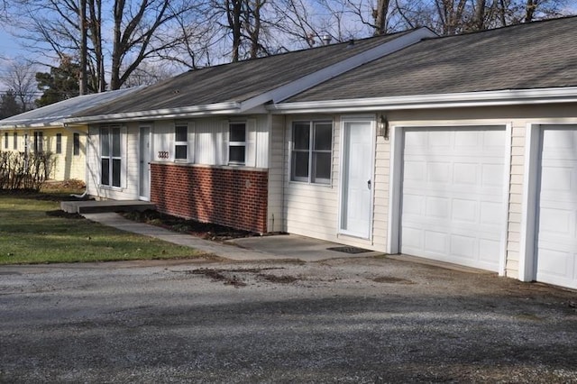 3333 Eastwood Dr, Fort Wayne, IN 46805 - view of side of property with an attached garage, a shingled roof, and brick siding