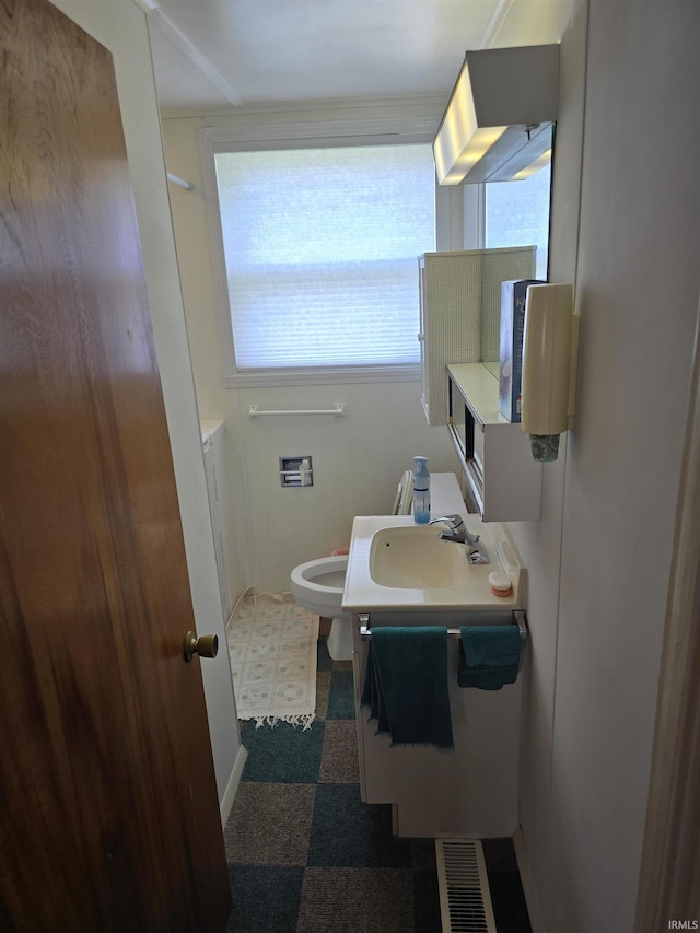 bathroom with healthy amount of natural light, vanity, baseboards, and tile patterned floors