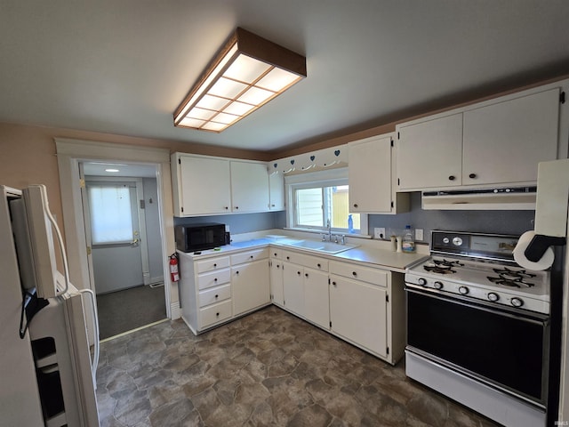 kitchen with gas range, a sink, freestanding refrigerator, black microwave, and under cabinet range hood