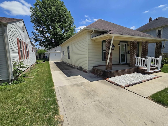 view of front facade with a porch, an outdoor structure, driveway, a front lawn, and a garage