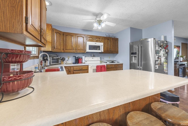 1376 N Hayland Dr, Jasper, IN 47546 - kitchen featuring white appliances, a peninsula, a sink, a textured ceiling, and light countertops