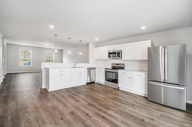 2170 Miami Trl, Huntington, IN 46750 - kitchen with appliances with stainless steel finishes, a sink, light countertops, a peninsula, and white cabinets