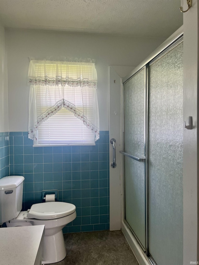 509 E Vincennes St, Orleans, IN 47452 - bathroom featuring a shower stall, toilet, wainscoting, tile walls, and vanity