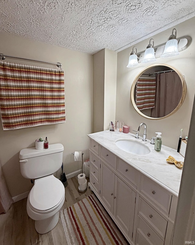 2146 N 20th St, Terre Haute, IN 47804 - bathroom featuring wood finished floors, toilet, baseboards, vanity, and a textured ceiling