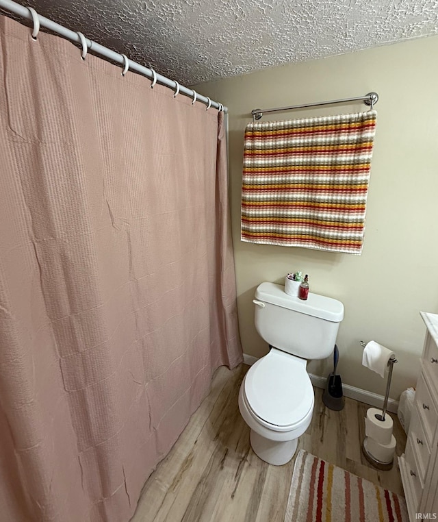 2146 N 20th St, Terre Haute, IN 47804 - full bath with wood finished floors, vanity, toilet, a shower with shower curtain, and a textured ceiling