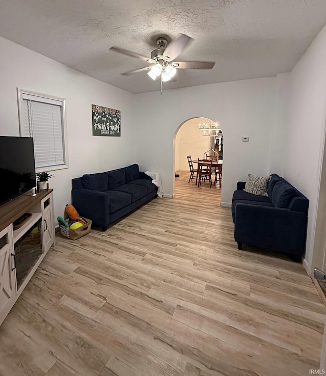 2146 N 20th St, Terre Haute, IN 47804 - living room featuring light wood finished floors, ceiling fan, a textured ceiling, a chandelier, and arched walkways
