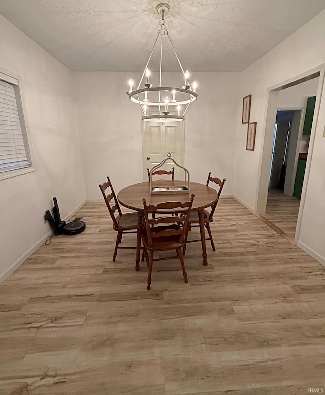 2146 N 20th St, Terre Haute, IN 47804 - dining space with a chandelier, light wood finished floors, a textured ceiling, and baseboards