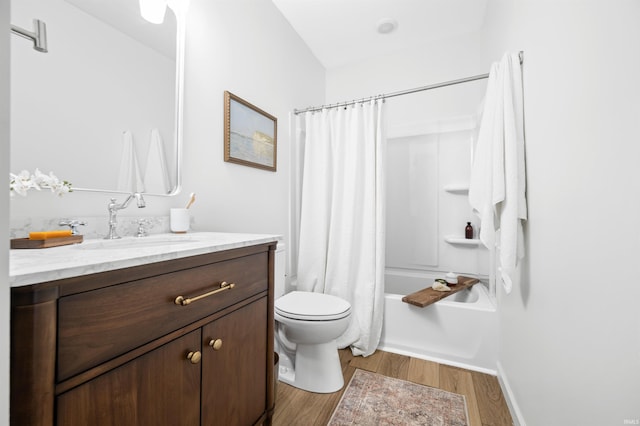 bathroom featuring wood finished floors, toilet, vanity, baseboards, and shower / bath combination with curtain