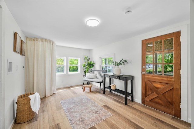 foyer entrance featuring light wood-style flooring and baseboards
