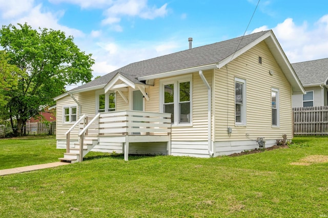 bungalow featuring a deck and roof with shingles