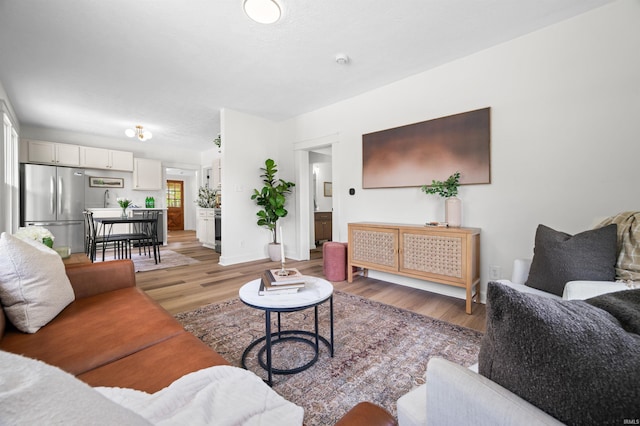 living area featuring light wood-type flooring and baseboards