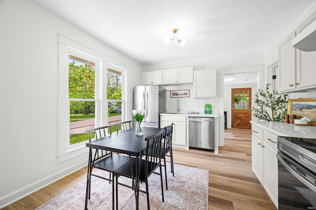 dining room featuring light wood-style flooring, baseboards, and a chandelier