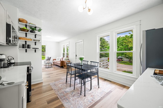 dining space featuring a textured ceiling and light wood finished floors