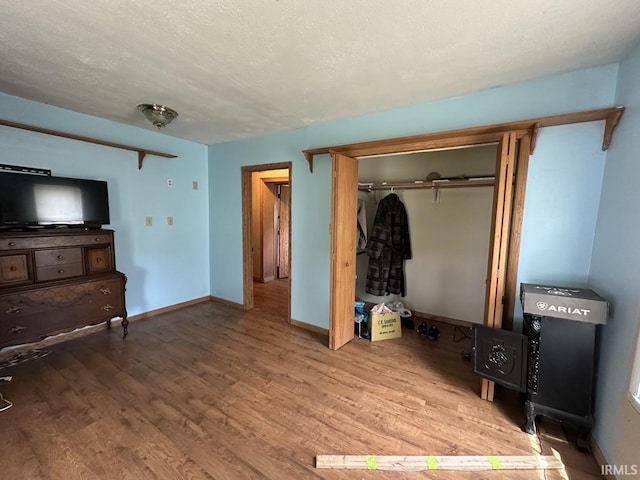 977 N Union Rd, Frankfort, IN 46041 - unfurnished bedroom with wood finished floors, a closet, baseboards, and a textured ceiling
