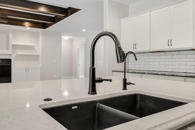 13335 Passerine Blvd, Fort Wayne, IN 46845 - kitchen view of a sink, decorative backsplash, light stone countertops, white cabinets, and recessed lighting
