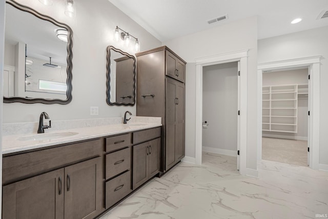 13335 Passerine Blvd, Fort Wayne, IN 46845 - bathroom featuring marble finish flooring, a walk in closet, double vanity, and baseboards
