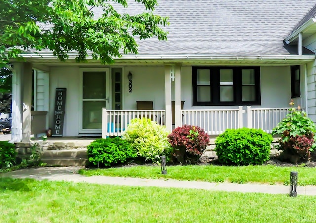 302 E Main St, Swayzee, IN 46986 - doorway to property with a porch, a shingled roof, and a yard