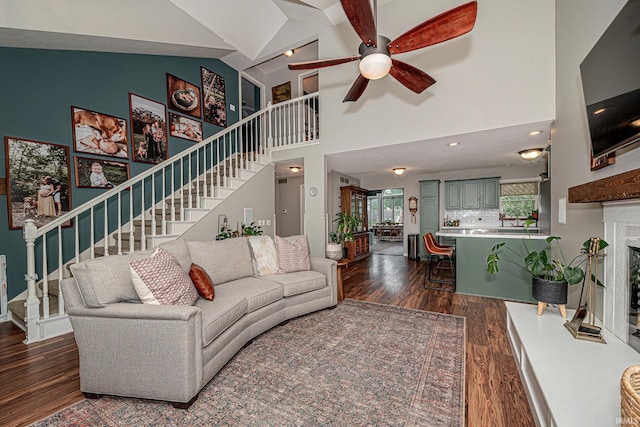 845 N Timberline Cir E, Warsaw, IN 46582 - living room featuring dark wood-type flooring, stairway, ceiling fan, high vaulted ceiling, and a glass covered fireplace