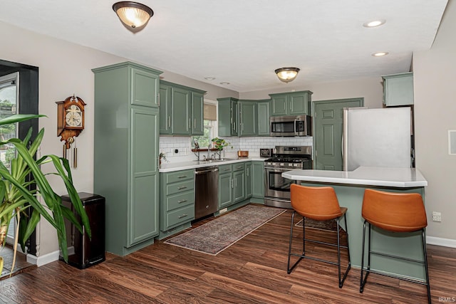 845 N Timberline Cir E, Warsaw, IN 46582 - kitchen with green cabinetry, appliances with stainless steel finishes, baseboards, tasteful backsplash, and recessed lighting