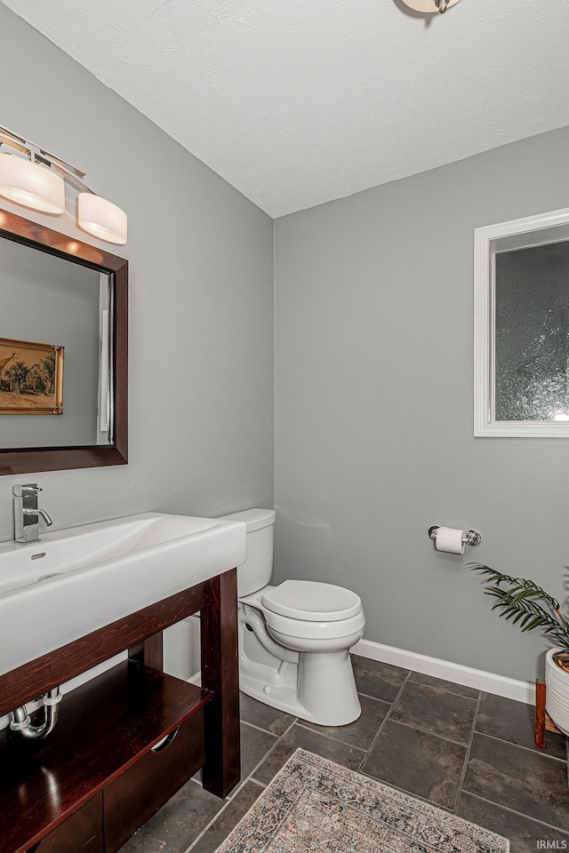 845 N Timberline Cir E, Warsaw, IN 46582 - half bath with toilet, vanity, stone tile floors, and baseboards