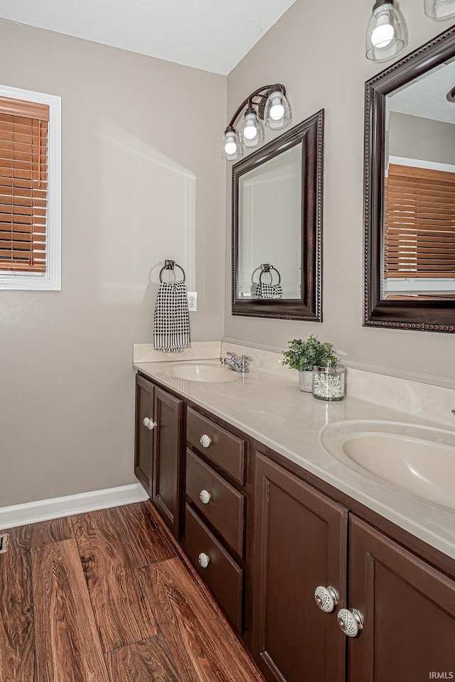 845 N Timberline Cir E, Warsaw, IN 46582 - bathroom with double vanity, baseboards, and wood finished floors