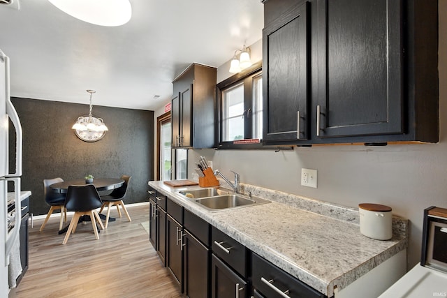 7205 Eby Rd, Fort Wayne, IN 46835 - kitchen featuring a sink, light wood-type flooring, an accent wall, a chandelier, and light countertops