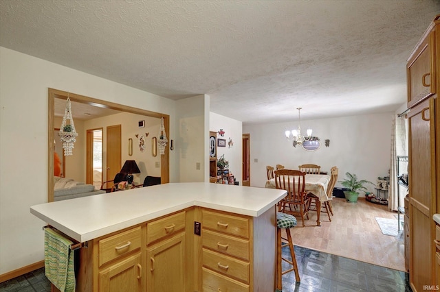 7373 Locust Lake Rd, Spencer, IN 47460 - kitchen with light countertops, a chandelier, a breakfast bar, baseboards, and open floor plan