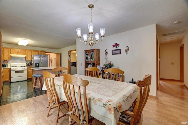 7373 Locust Lake Rd, Spencer, IN 47460 - dining area with light wood-type flooring, a chandelier, and baseboards