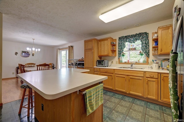 7373 Locust Lake Rd, Spencer, IN 47460 - kitchen featuring a sink, open shelves, a breakfast bar, a textured ceiling, and a chandelier