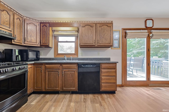 608 Fieldstone Ln, Middlebury, IN 46540 - kitchen featuring black appliances, a sink, dark countertops, light wood-type flooring, and ventilation hood