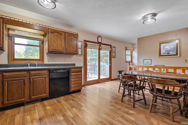 608 Fieldstone Ln, Middlebury, IN 46540 - kitchen with black dishwasher, a sink, dark countertops, and light wood finished floors