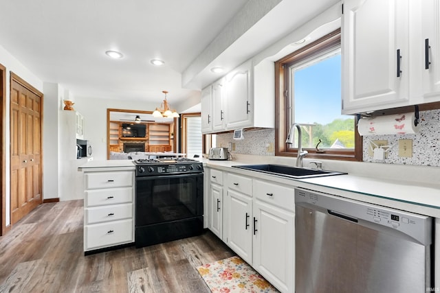 kitchen featuring stainless steel dishwasher, black gas range, a sink, light countertops, and wood finished floors