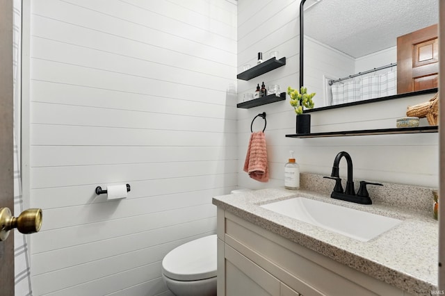 full bath featuring toilet, vanity, a textured ceiling, a shower with shower curtain, and wooden walls