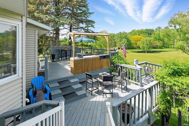 wooden deck featuring outdoor dining area, a fire pit, and a yard